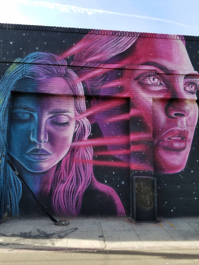 Two women's faces on a garage door. DTLA.