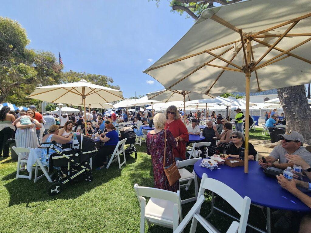 Greek festival guests eating at picnic tables. San Fernando Valley
